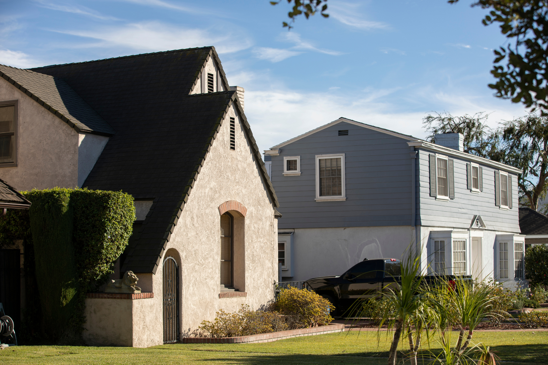 historic-home-insurance-north-carolina.png Two older residential homes in a quiet neighborhood with blue skies above