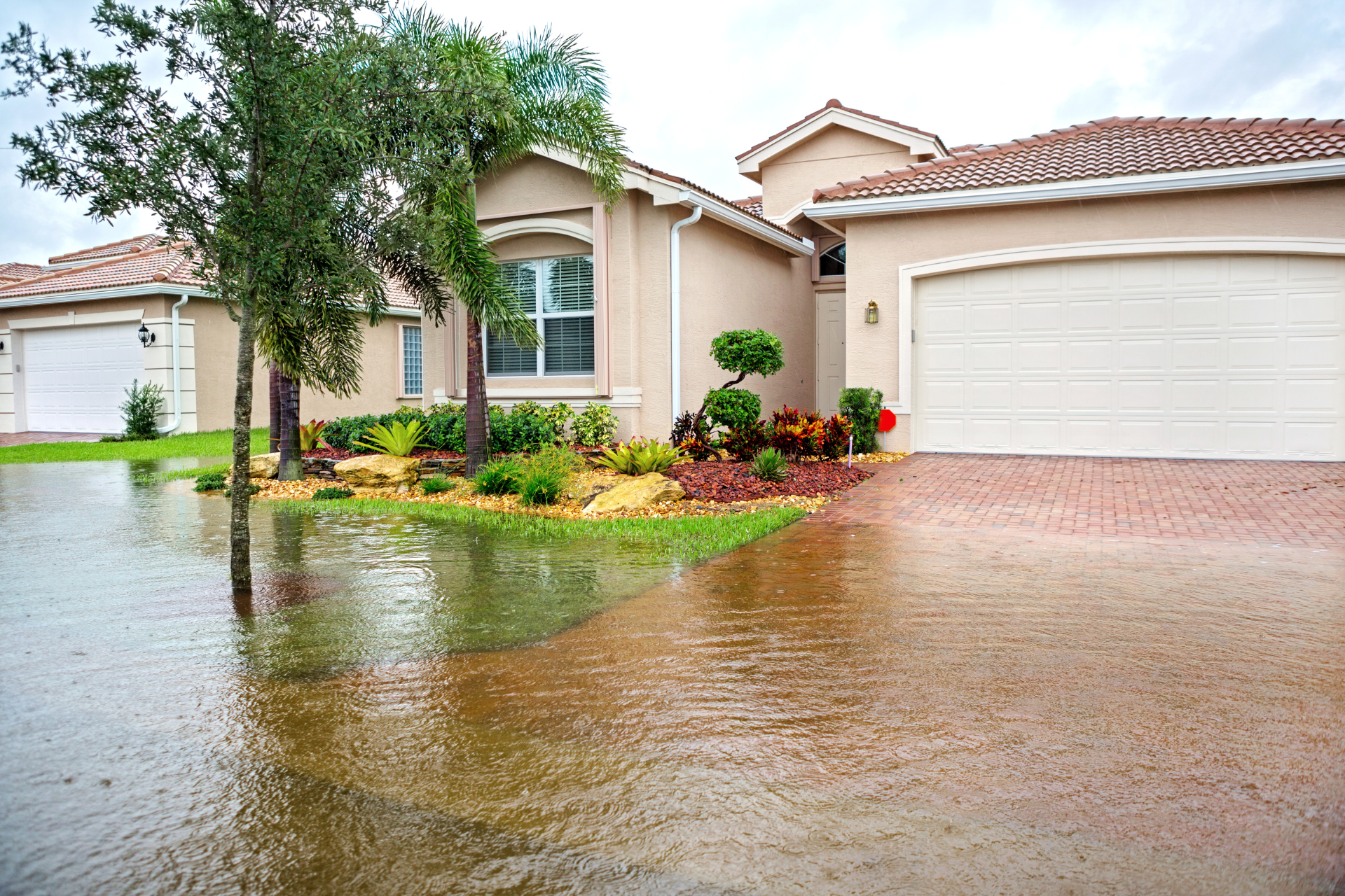 suburban-home-flood-insurance-north-carolina.png Floodwater pooling in the front yard of a suburban home after a heavy storm in North Carolina