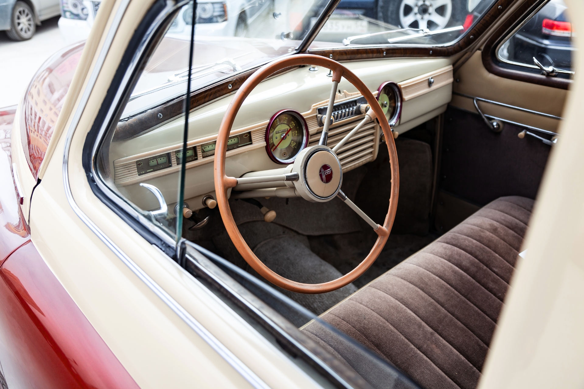 Interior view of a restored vintage car with a classic wooden steering wheel and retro dashboard, representing collectible car coverage.
