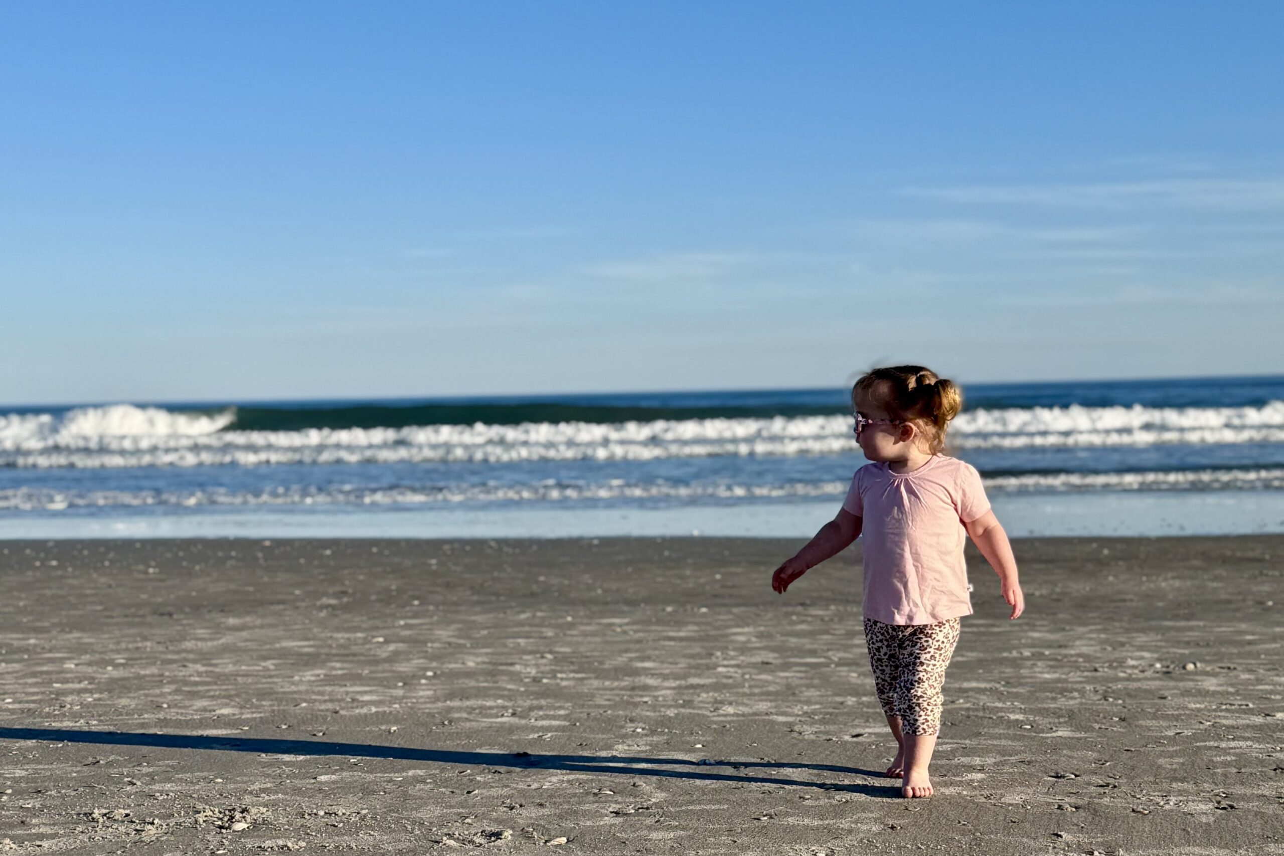 Young child walking on a North Carolina beach, symbolizing family protection and financial security provided by FinPoint Insurance Group.