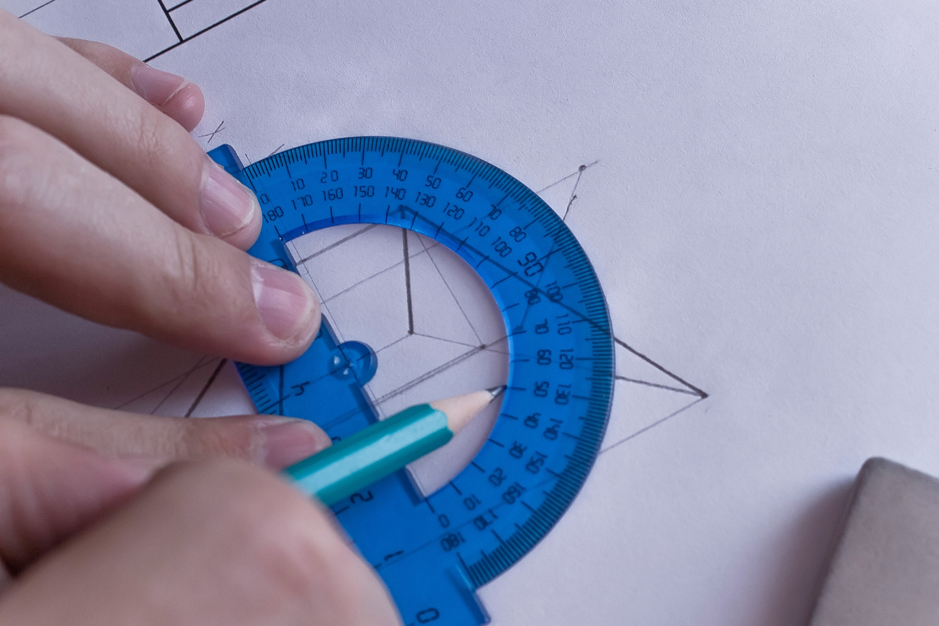 engineer using protractor and pencil on technical design and drafting plans