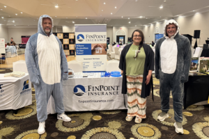FinPoint Insurance Southport team at BCAR Member Appreciation Night in Brunswick County wearing shark costumes at vendor booth